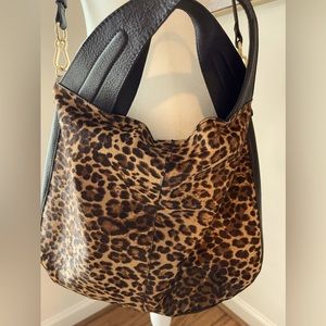 Vince Camuto leather handbag.  Leopard front texture, black back. Snap closure.